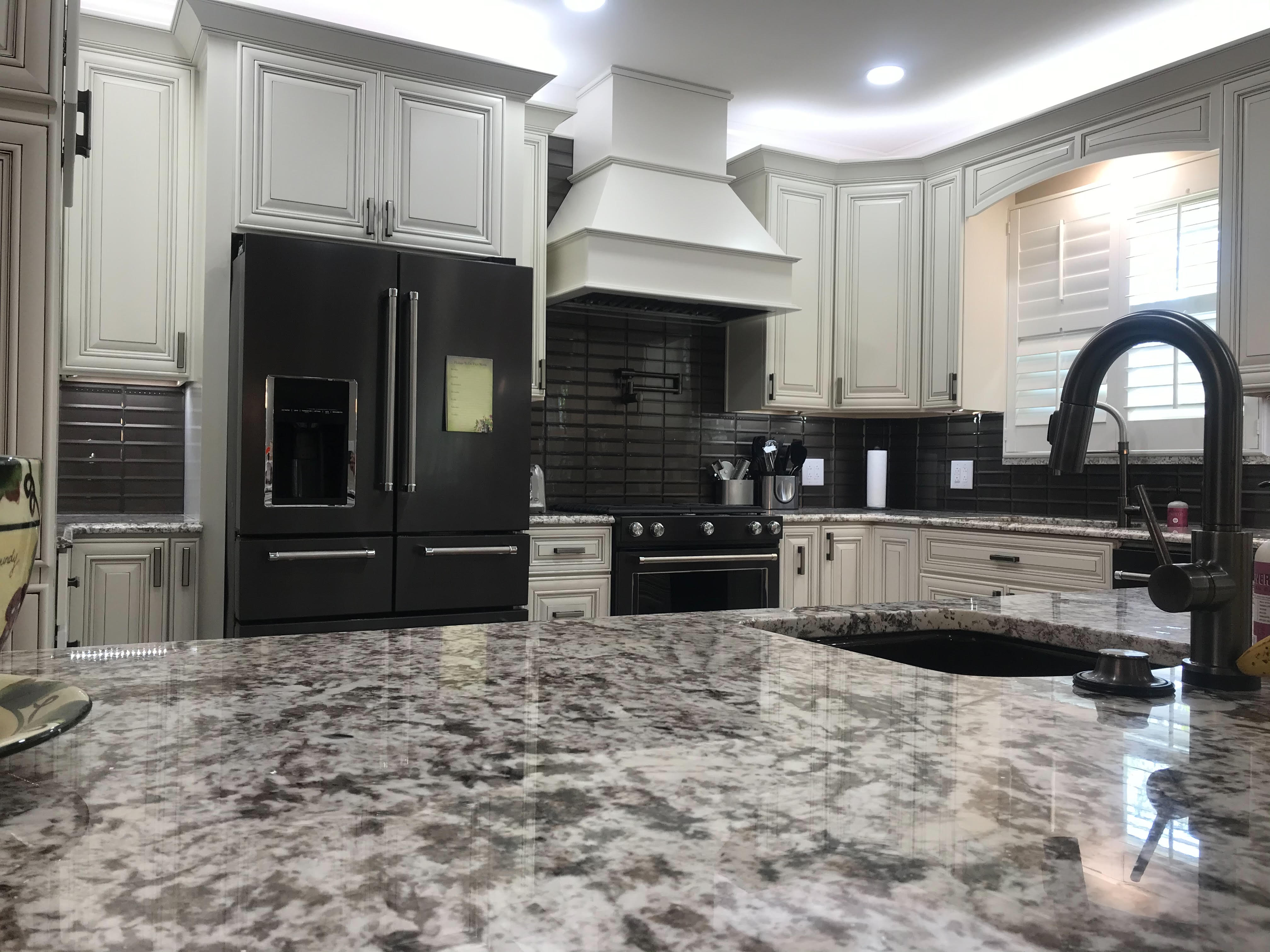 A modern looking kitchen matte black with marble